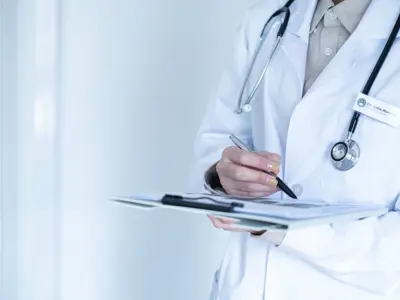 medical examiner writing on clipboard