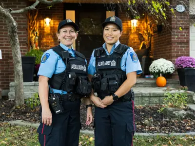 Two Female Auxiliary Officers standing in front of a porch 