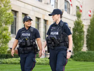 Two Female LPS officers walking on manicured property